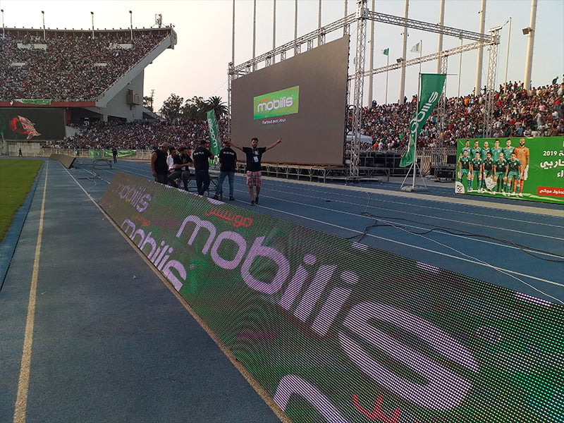 Stadium lit up with perimeter LED boards during a match