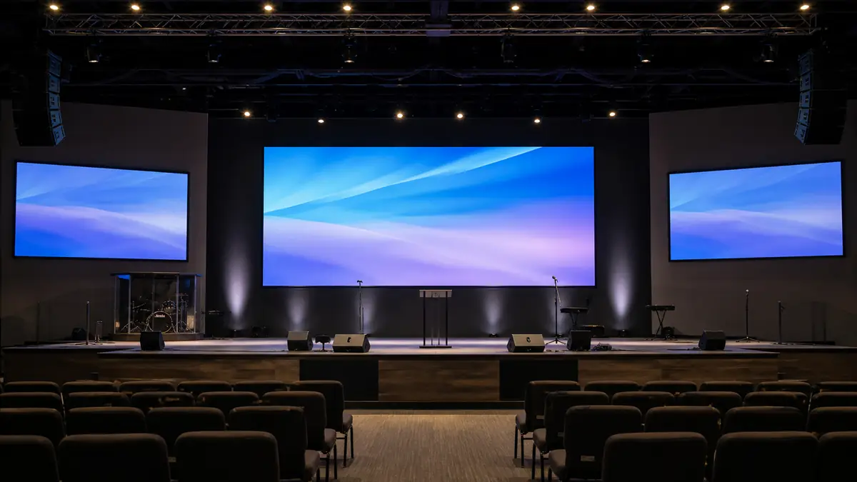 Church stage with a central LED video wall and two side display screens